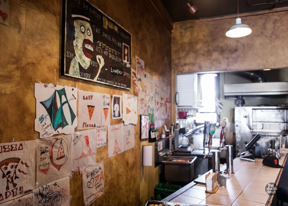 The counter and kitchen, with pizza art along the wall
